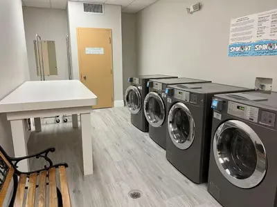 a laundry room with three washing machines and a counter at Condo near Disney Springs-Free shuttle to Parks in Orlando