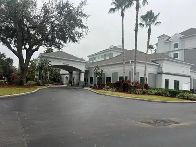 a driveway in front of a house with palm trees at Inspiration condo near Disney with free shuttle in Orlando