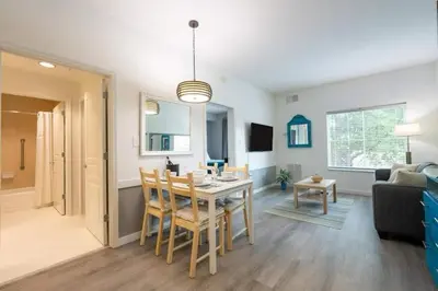 a kitchen and living room with a table and chairs at Inspiration condo near Disney with free shuttle in Orlando