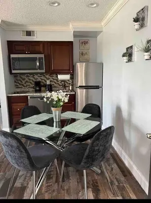 a kitchen with a table with chairs and a refrigerator at Condo 2 Queen beds-Disney-Universal in Orlando
