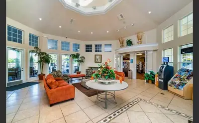 a large living room with orange chairs and a table at Apartment Disney Universal Epic in Orlando