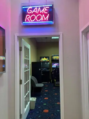 a game room with a neon sign on the wall at Renovated Condo near Disney Free Shuttle to Parks in Orlando