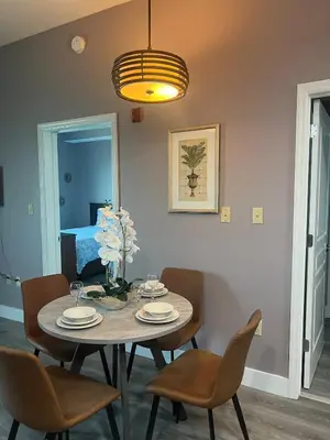 a dining room with a table and chairs and a bed at Renovated Condo near Disney Free Shuttle to Parks in Orlando
