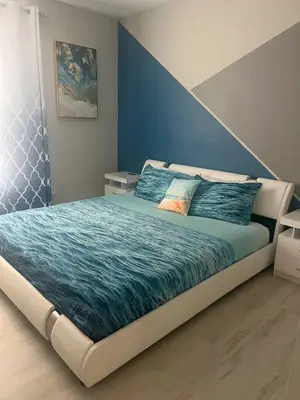 a bedroom with a large bed with a blue wall at Amazing Condo near Disney in Kissimmee