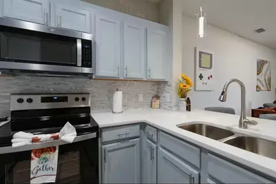 a kitchen with a stove and a sink and a microwave at Amazing Condo near Disney in Kissimmee