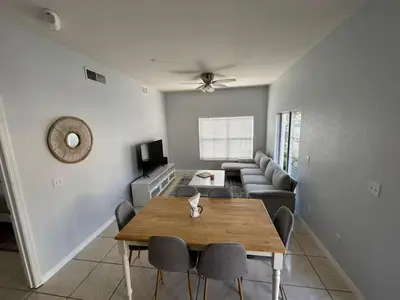 a living room with a wooden table and chairs at Renovated 4 bed3 bath Townhome near Disney in Kissimmee