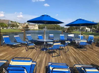 a deck with blue chairs and tables and umbrellas at Renovated 4 bed3 bath Townhome near Disney in Kissimmee