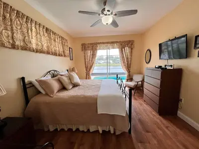 a bedroom with a bed and a ceiling fan at Villa near Disney Jacuzzi Pool 4bed-3baths in Kissimmee