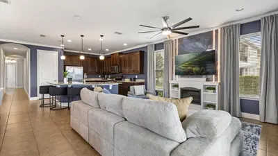 a living room with a couch and a kitchen at Upstay Spacious 5BR Villa Private Pool and Hot Tub in Orlando