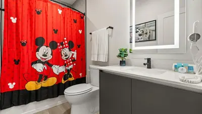 a bathroom with a red shower curtain with mickey mouse on it at Contemporary 4BR Townhome with Pool & Themed Rooms in Orlando