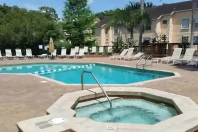 a swimming pool with a hot tub in the middle at 3BR Condo Near Disney, with Clubhouse, Pool and Gym in Kissimmee