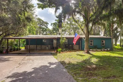 a house with an american flag in front of it at Lakefront Home with Hot Tub and Dock in Orlando! in Orlando