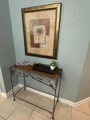 a table with a picture and a laptop on it at PalmTree Oasis 3 bedroom Condo at Windsor Hills in Orlando