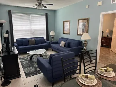 a living room with blue couches and a table at PalmTree Oasis 3 bedroom Condo at Windsor Hills in Orlando