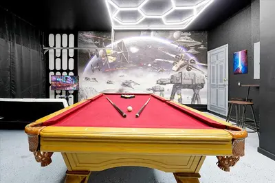 a pool table with a red cover in a room at 6 Bedroom Villa located in Windsor Hills 3 miles to Disney Free Heated Pool & Spa Game Room with PS5! in Orlando