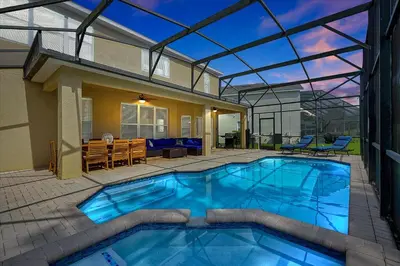 a swimming pool in a patio with a house at 6 Bedroom Villa located in Windsor Hills 3 miles to Disney Free Heated Pool & Spa Game Room with PS5! in Orlando