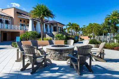 a patio with chairs and a table and a fire pit at 24-7 Vacation Club! Affordable Vacation Stays, Multiple Units Available, All Over Florida! Name your price today! in Kissimmee
