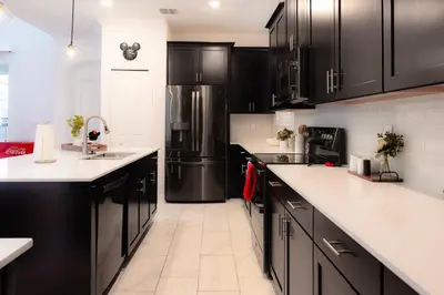 a kitchen with black cabinets and a refrigerator at Storey Lake Resort 515 - Hosted by Top Villas in Kissimmee