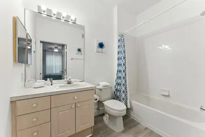a white bathroom with a toilet and a sink at Last Minute Disney Luxury Condo with Balcony. Book Now WP77 in Orlando