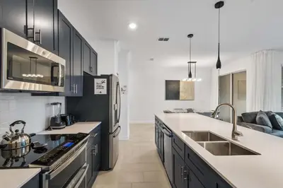a kitchen with black cabinets and white counter tops at Storey Lake Resort 510 - Hosted by Top Villas in Kissimmee
