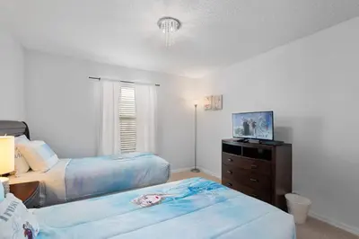 a bedroom with two beds and a dresser in it at Storey Lake Resort 511 - Hosted by Top Villas in Kissimmee