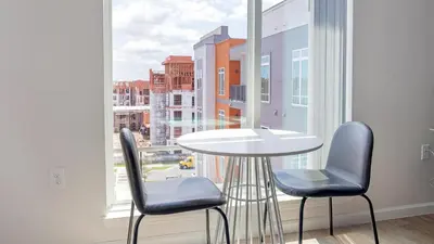 a table and two chairs in front of a large window at Landing Incredible 1BD Gym Clubhouse in Orlando