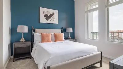 a bedroom with blue walls and a bed with orange pillows at Landing Incredible 1BD Gym Clubhouse in Orlando