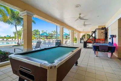 a pool table on a patio with a swimming pool at Magnificent 2 Bedroom Apt Vista Cay Resort 107 in Orlando