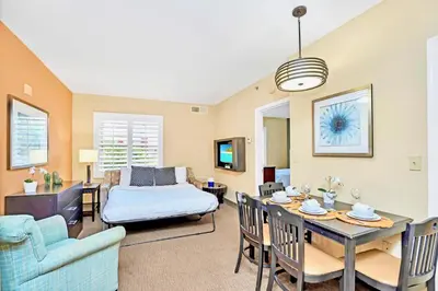 a living room with a bed and a dining room at 1BR Condo Near Universal Studio with Hot Tub & Pool in Orlando