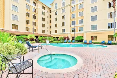 a hot tub in a courtyard with chairs and a building at 1BR Condo Near Universal Studio with Hot Tub & Pool in Orlando