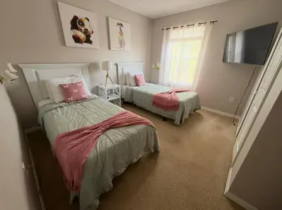 a bedroom with two beds and a flat screen tv at Family & Group Haven-Resort Style Living-Near Disney in Kissimmee