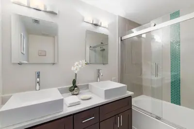 a white bathroom with two sinks and a shower at Amazing 3BDR House with pool in Kissimmee