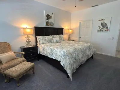 a bedroom with a bed and a chair and two lamps at The Windsor Hideaway in Orlando