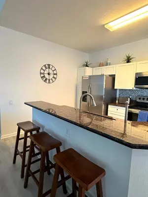 a kitchen with a counter with stools and a counter top at The Windsor Hideaway in Orlando