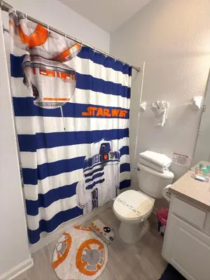 a bathroom with a patriots shower curtain and a toilet at The Windsor Hideaway in Orlando