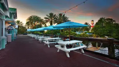 a row of white picnic tables with blue umbrellas at Disney's Old Key West Resort in Orlando