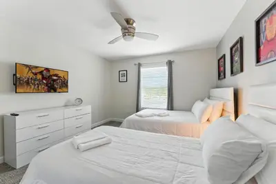 a bedroom with two beds and a ceiling fan at Comfort Stay with Pool Near Attractions in Kissimmee