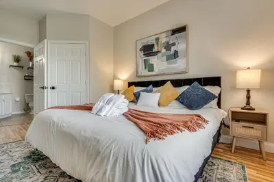 a bedroom with a large bed with blue and yellow pillows at 4 Mi to Disney Family-Friendly Resort Getaway! in Orlando