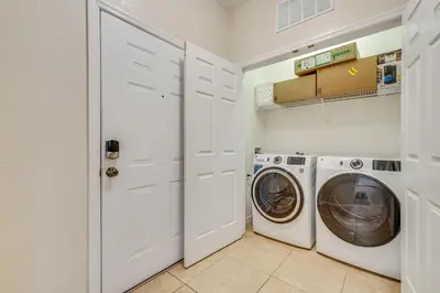 a white laundry room with a washer and dryer at 4 Mi to Disney Family-Friendly Resort Getaway! in Orlando
