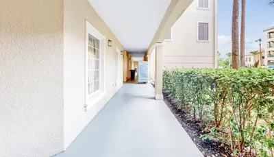 a hallway of a white house with a sidewalk at Worldquest Resort Luxurious Pet Friendly Condo in Orlando