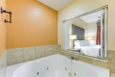 a bath tub in a room with a bedroom at Poolside Bliss and Theme Park Thrills Orlando Oasis in Orlando