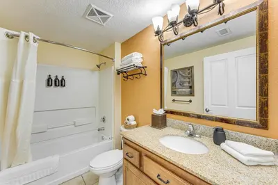 a bathroom with a sink and a toilet and a mirror at Poolside Bliss and Theme Park Thrills Orlando Oasis in Orlando