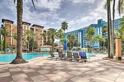 a pool at a resort with chairs and palm trees at Poolside Bliss and Theme Park Thrills Orlando Oasis in Orlando