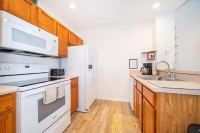 a kitchen with white appliances and wooden cabinets at Charming 3BrTownhome near Disney in Kissimmee