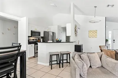 a living room with a couch and a kitchen at Casa térrea c/ piscina e 2 suítes, sem carpete in Kissimmee