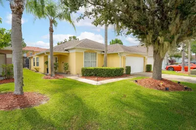 a house with palm trees in a yard at Casa térrea c/ piscina e 2 suítes, sem carpete in Kissimmee