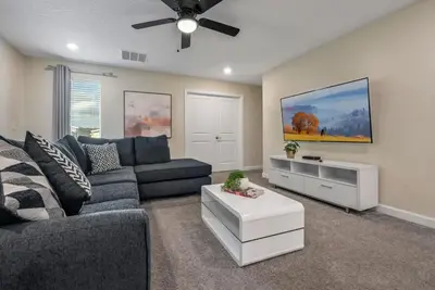 a living room with a couch and a ceiling fan at villa 9 quartos com temas, pertinho da Disney! in Kissimmee