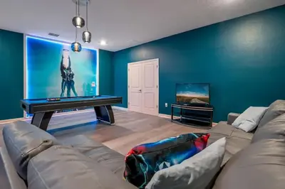 a living room with a couch and a pool table at villa 9 quartos com temas, pertinho da Disney! in Kissimmee