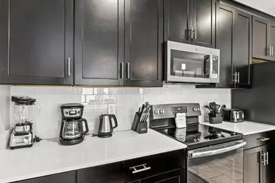 a kitchen with black cabinets and a stove top oven at Private Pool 4BR Home in Orlando in Kissimmee