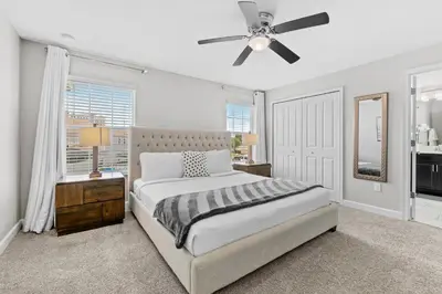 a bedroom with a bed and a ceiling fan at Private Pool 4BR Home in Orlando in Kissimmee